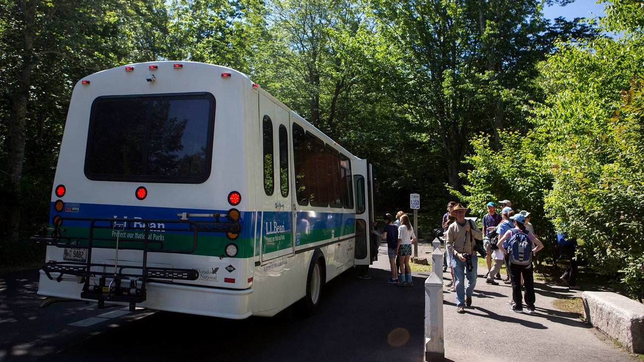 Bus with people deboarding at a sidewalk