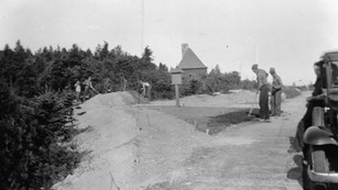 B&W Photo of men with shovels along roads
