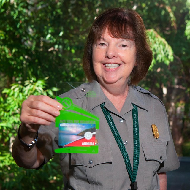 A ranger holds up a wallet-sized card in a plastic hangtie sleeve