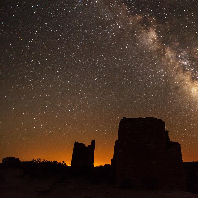 milkyway and hundreds of stars scene with an adobe structure in the foreground