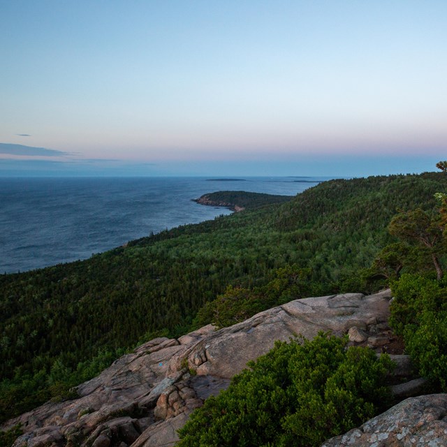 view from a mountain top of the coast with haze on the horizon