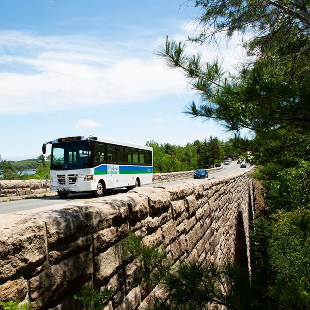 Bus and cars driving over a stone bridge