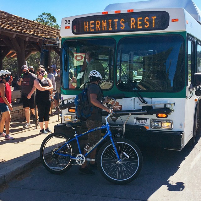 man loading his bike on the front of a NPS shuttle bus