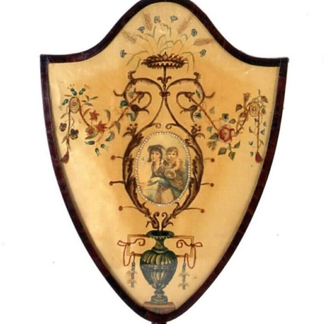 Two fire screens in the shape of shields stand next to each other on a white background.