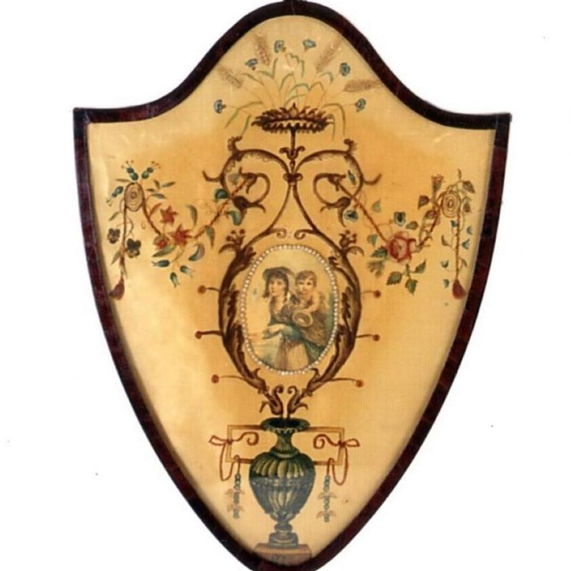 Two fire screens. The shield-shaped screens are mounted on a single pole with a round base.