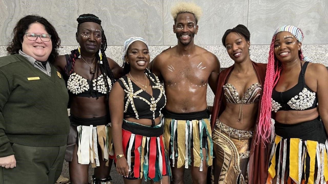 One ranger and five African dancers pose for a photograph.