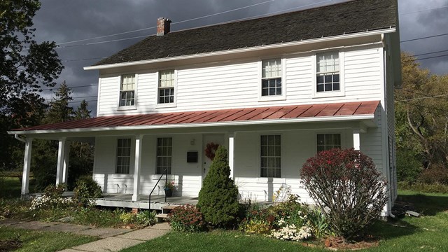 a white two-story home with a broad front porch