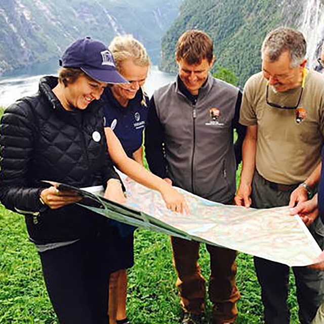 A group of people stand together looking at a map.