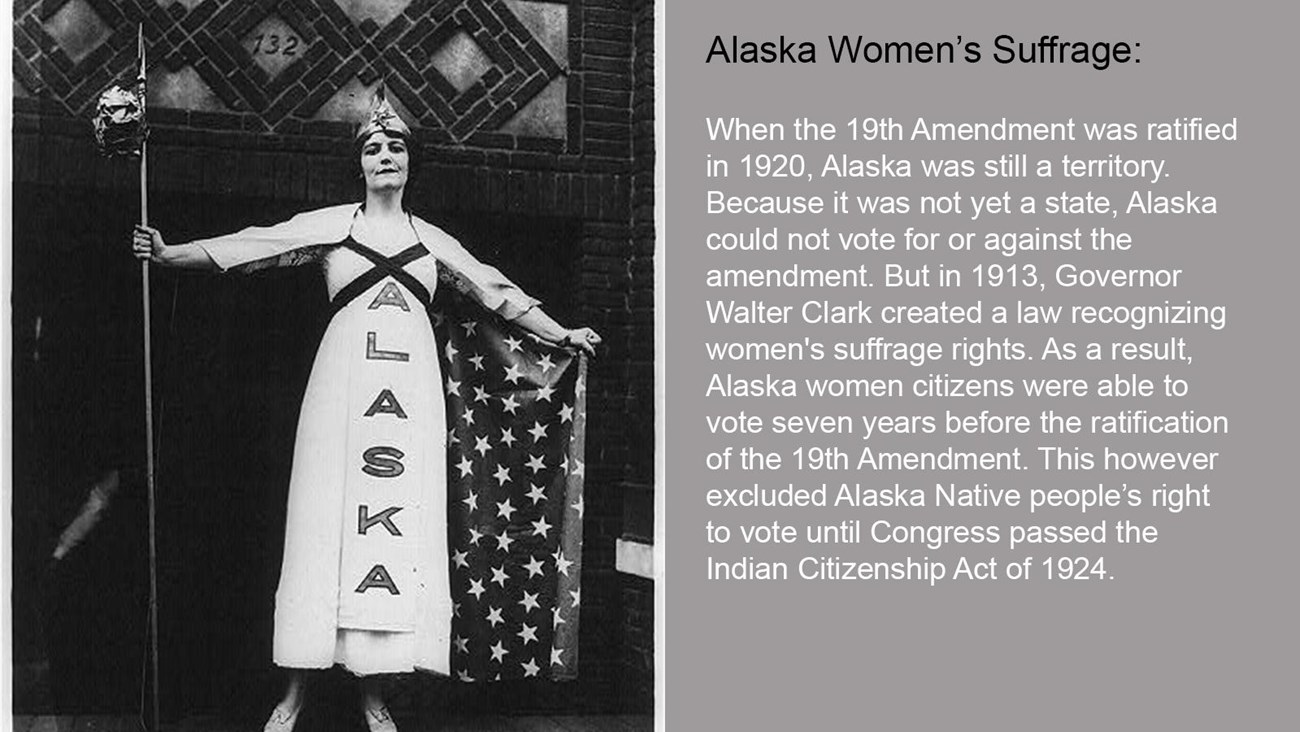 A woman stands holding a rod, in a dress that has "Alaska" printed on side.
