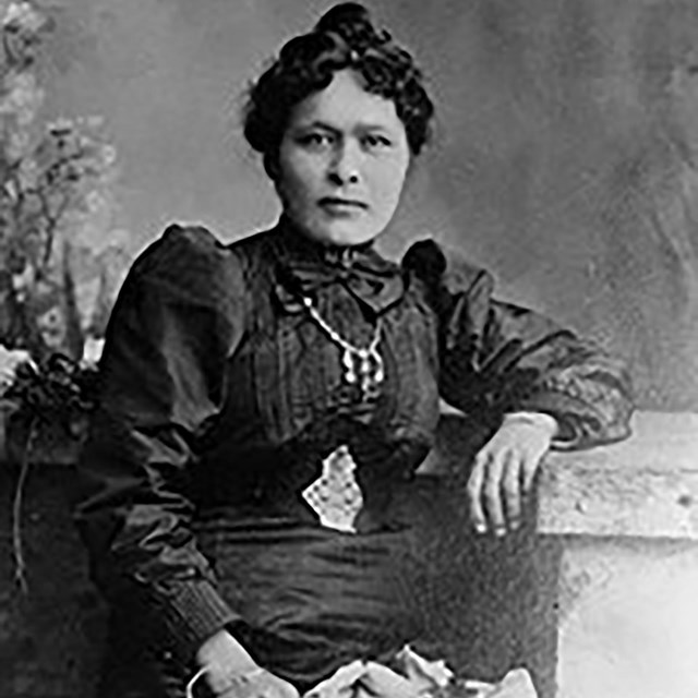 A woman in an elegant dress poses for the camera.