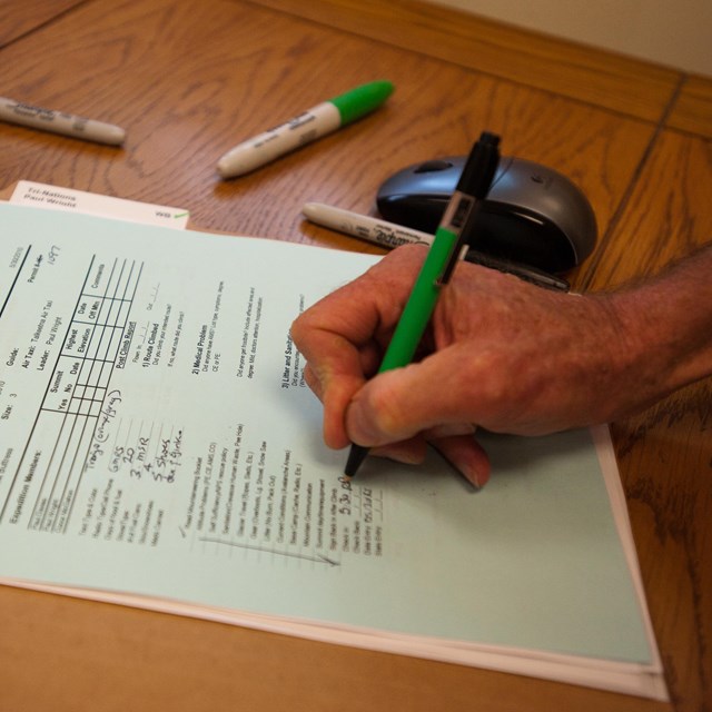 a hand files out a registration form