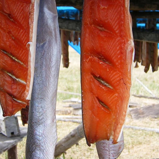 An image of sliced fish hanging on a wooden rack