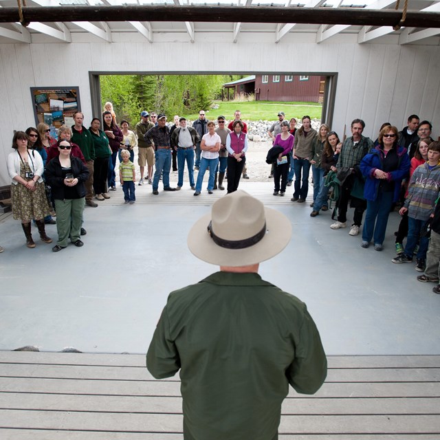 a NPS employee speaks to a group of community members in a large room