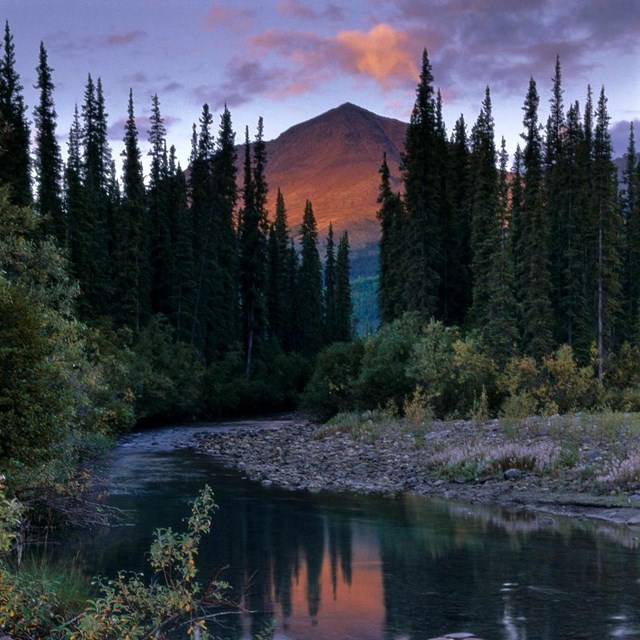 alpen glow on a mountain beyond a river