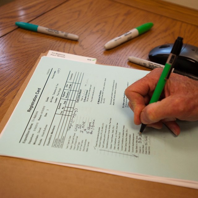 a close up of a hand filling out a registration form