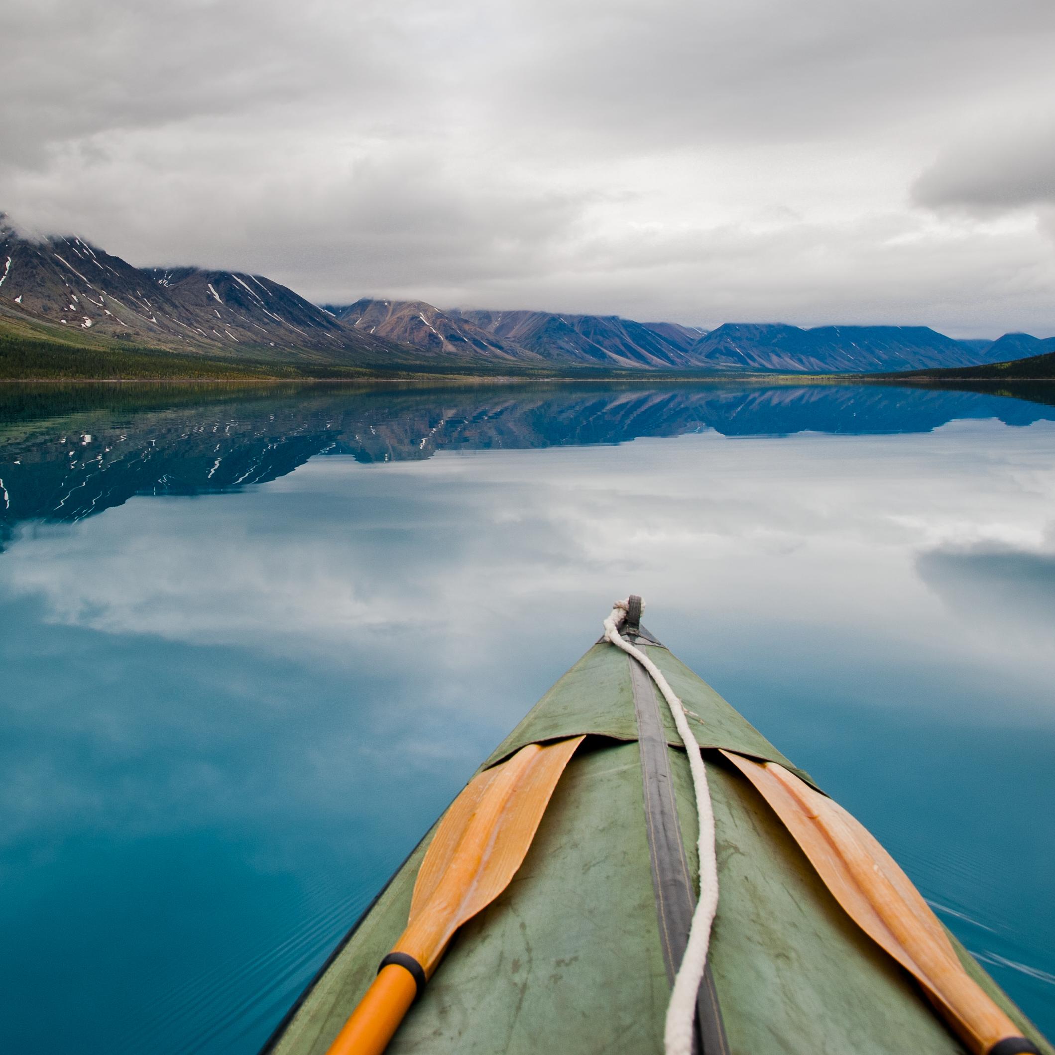 a canoe paddles through turquoise waters