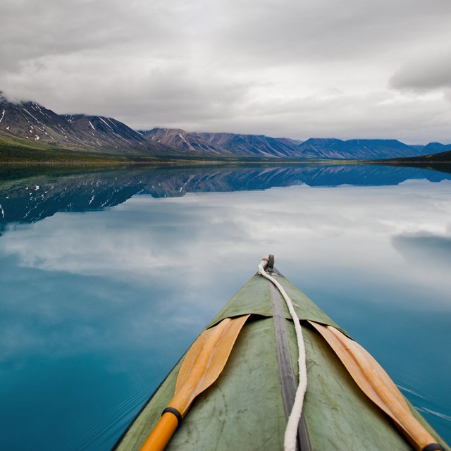 a canoe paddles through turquoise waters