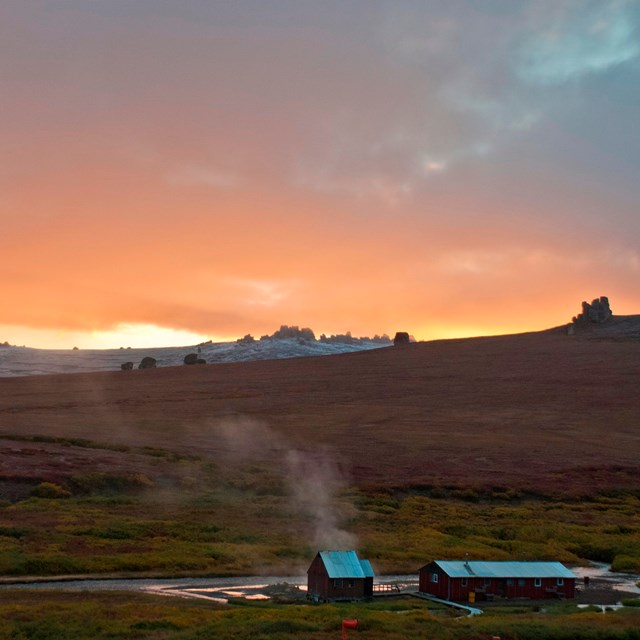 steam rises from Serpentine Hot Springs at sunset