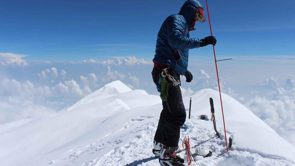 a scientist probes the top of a mountain