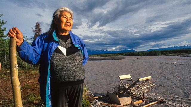 Katie John stands near a fishwheel at her family fishcamp.