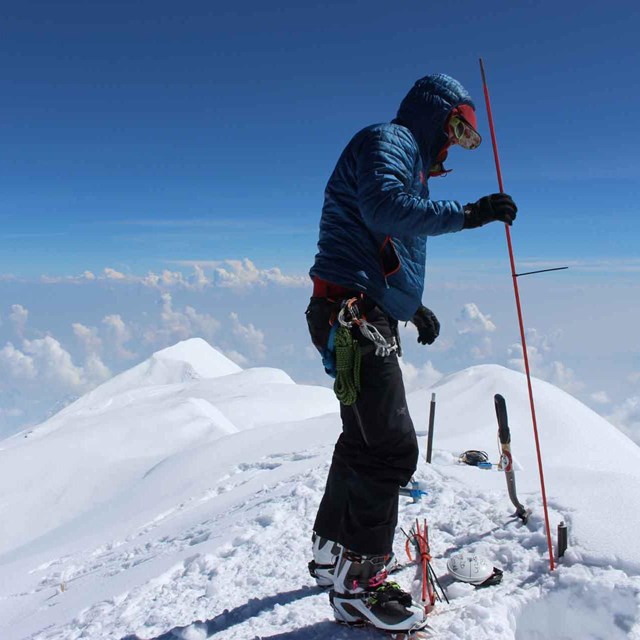 a scientist probes the top of a mountain