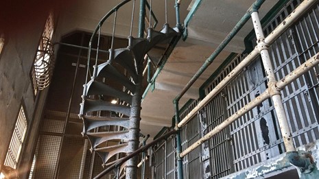 A cell block in Alcatraz with spiral staircase and prison bars