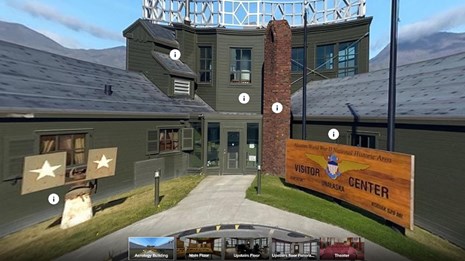 Color photo of a building with a visitor center sign on the right, and info icons. 
