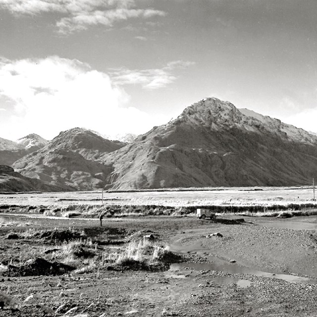Black and white landscape photo of mountains and water. 