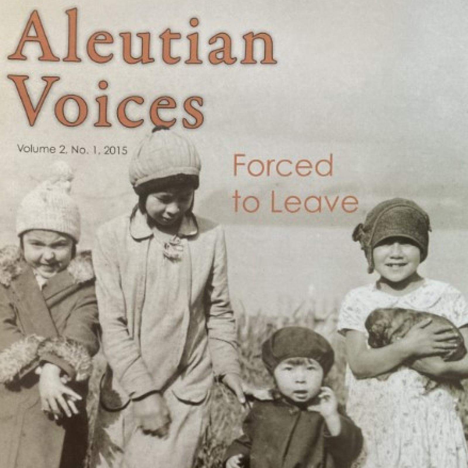 A group of four Indigenous girls wearing dresses, one holding a puppy, stand along a coastline.