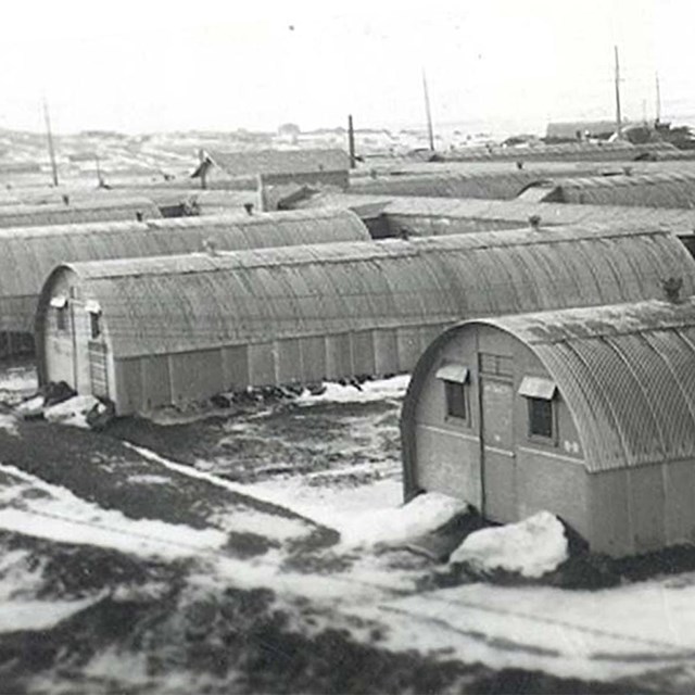 Connected, semi-circular huts in a historic scene.