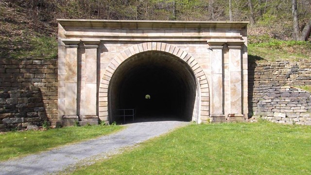 A railroad tunnel made out of stone.