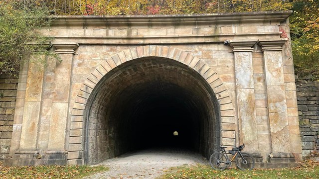A railroad tunnel made out of stone.