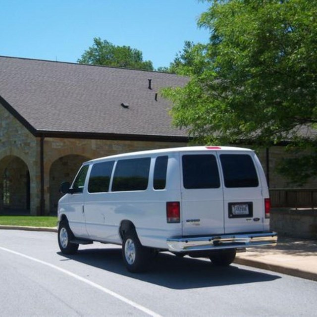 A white van parked by a building. 