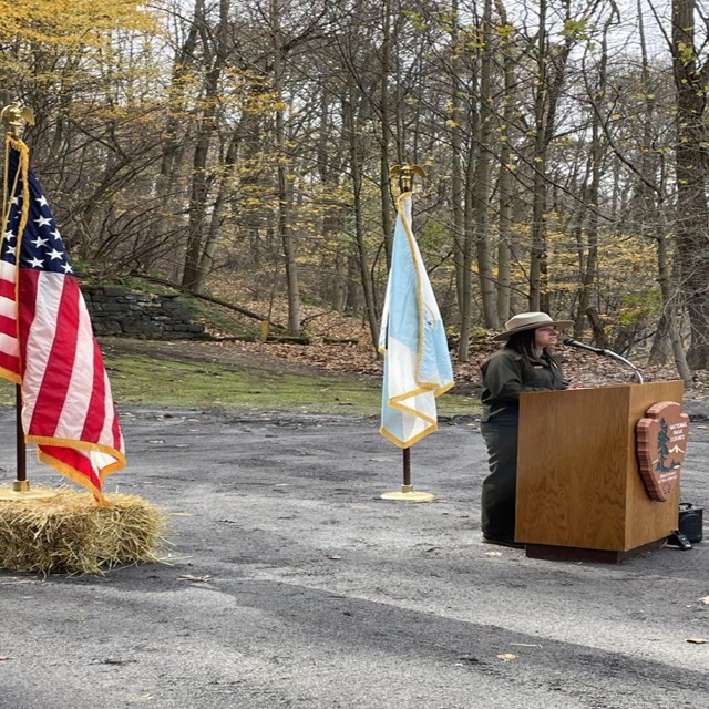 A park ranger standing at a podium during a press conference.