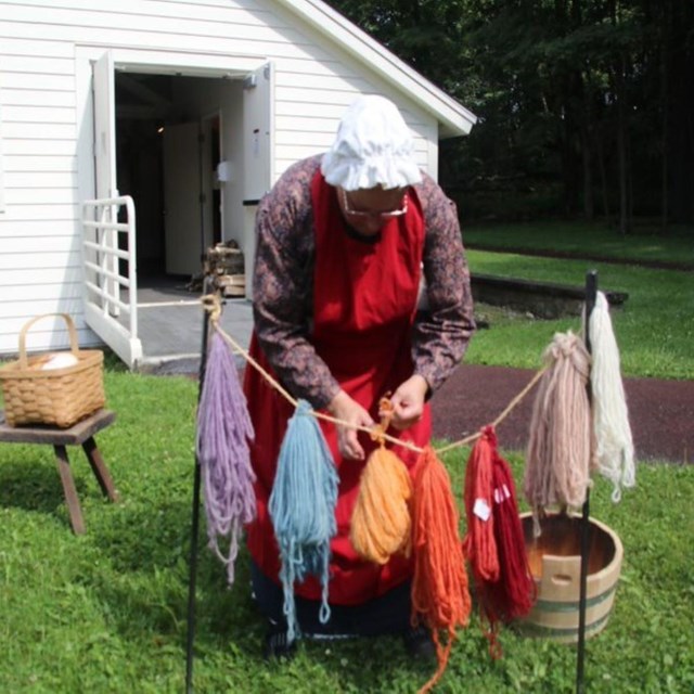 A costumed park ranger conducting a natural dyes demonstration.