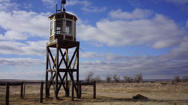 A guard tower rising above the prairie.