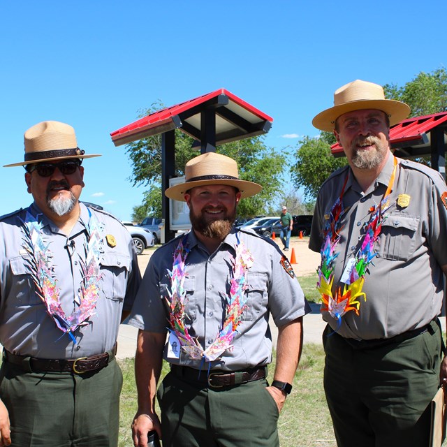 Three male park rangers smiling at the camera