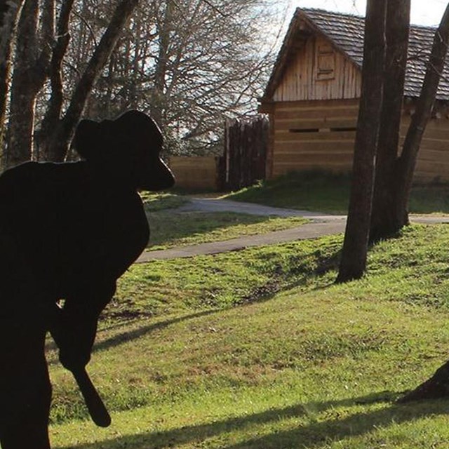 A silhouette of a militia soldier carrying a musket approaches a wooden fort