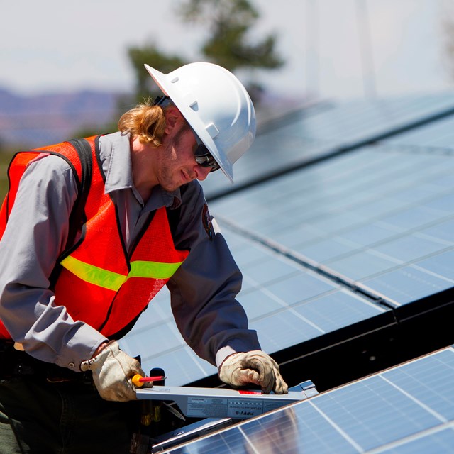 A technician works on solar panels