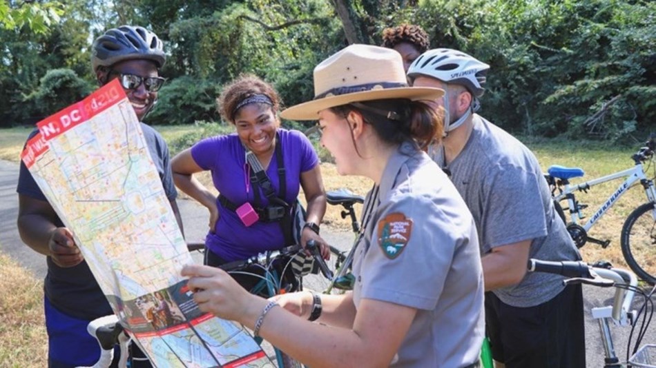 A ranger shows a map to bikers on the Anacostia River Trail