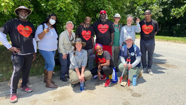 A group of volunteers standing in front of trees.