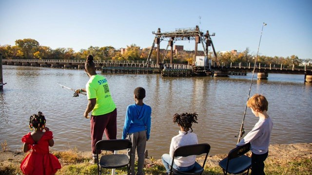 A member of the Friends of Anacostia Park teach children how to fish