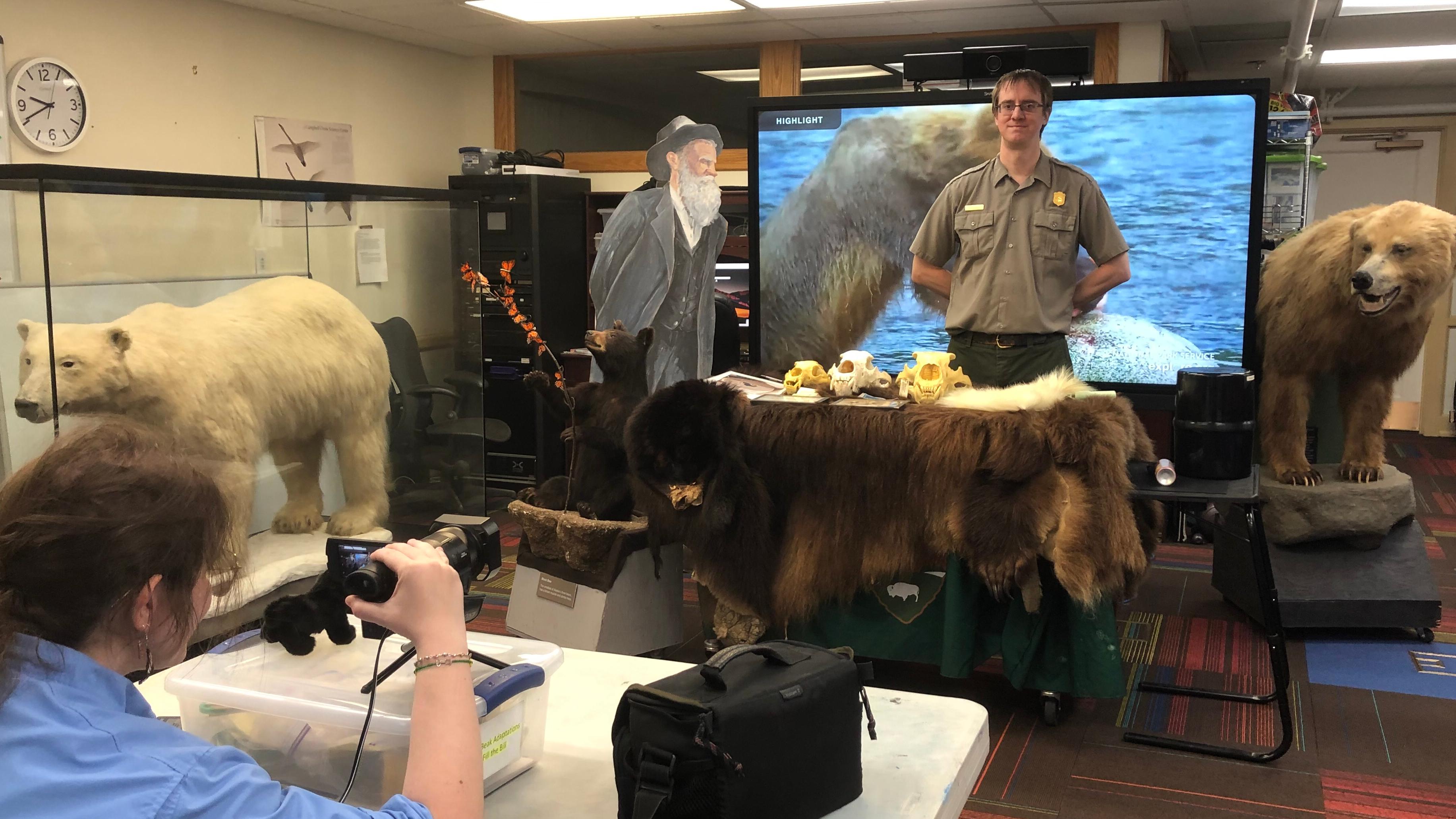 Ranger presenting bear pelts and interpretive itesms to virtual audience