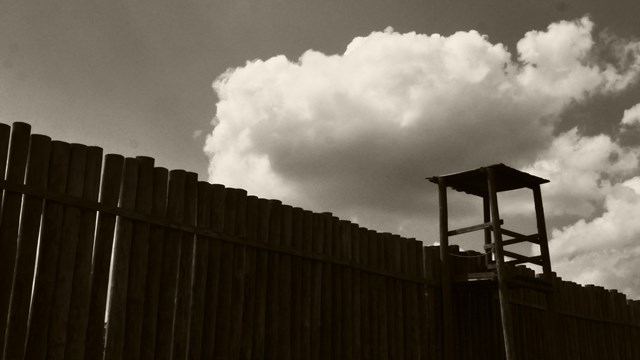 Large wooden wall with a lookout post in the far right.