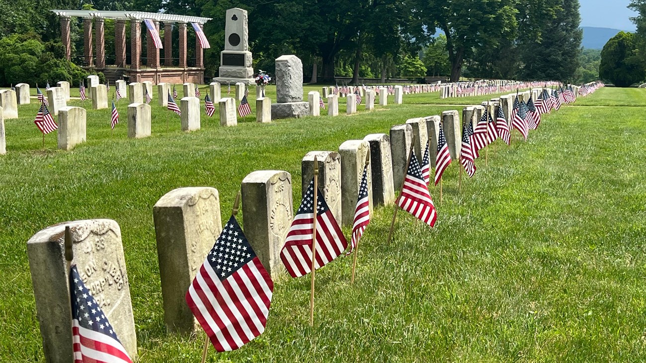 American flags in front of white headstones