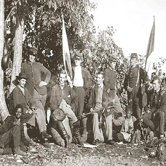 group of solders posting for photo with wooden platform behind them