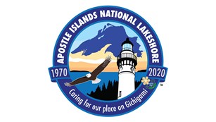 The 50th anniversary logo, featuring: Lake Superior, lighthouse, flowers, islands, eagle, and water.