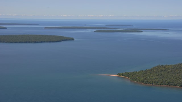 An aerial photo of green forested islands surrounded by blue water.