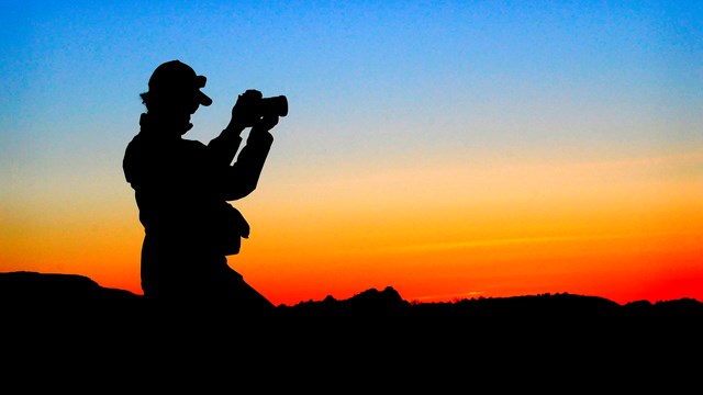 silhouette of a photographer at sunset