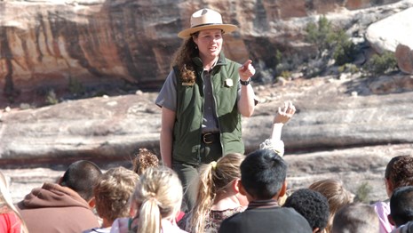 a park ranger stands before a group of students